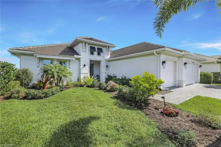 View of front of house featuring a front lawn and a garage