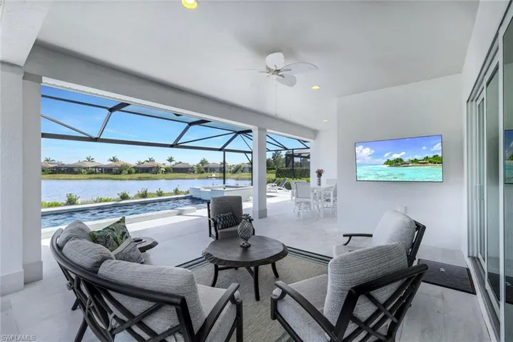 View of patio featuring ceiling fan, a lanai, and a water view