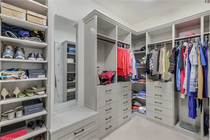 Spacious closet with light carpet
