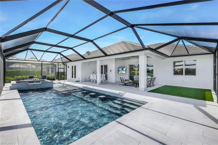 View of swimming pool with a lanai, a patio, and an in ground hot tub