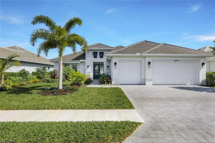 View of front of property featuring a garage and a front yard