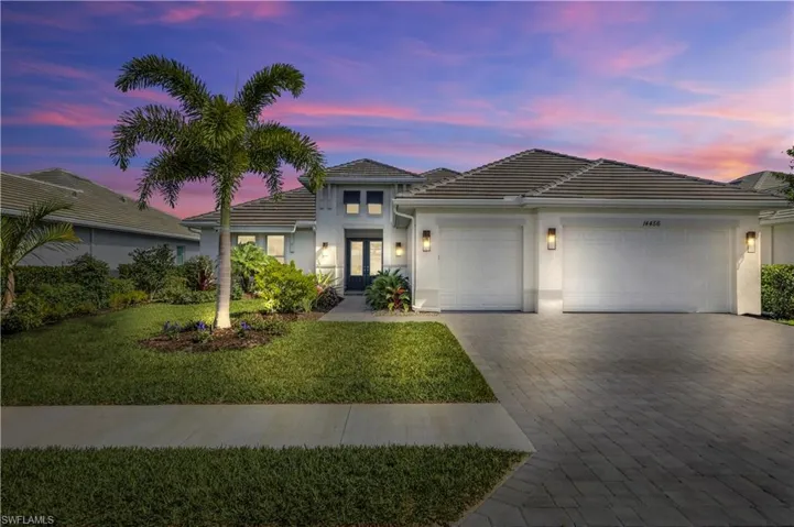 View of front of house with a garage and a lawn