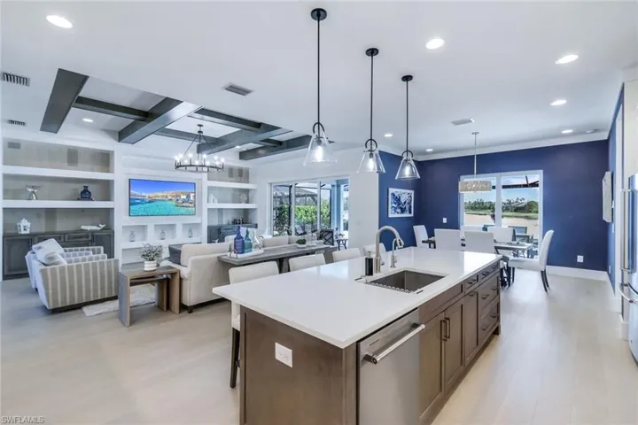 Kitchen with an island with sink, sink, stainless steel dishwasher, light hardwood / wood-style flooring, and plenty of natural light