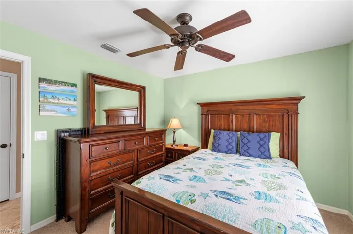 Bedroom with light colored carpet and ceiling fan