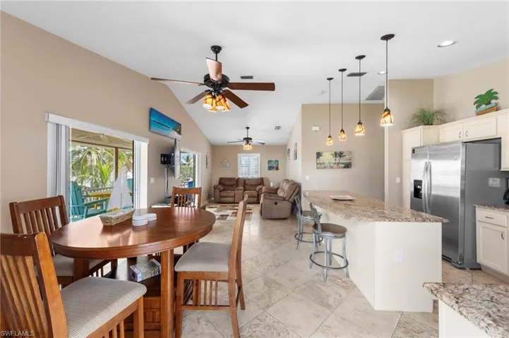 Dining space with a ceiling fan and lofted ceiling