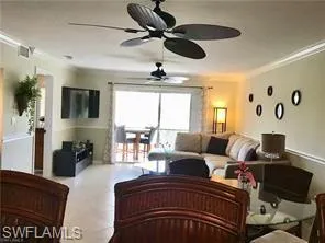 Kitchen with stainless steel appliances, ceiling fan, a raised ceiling and light tile patterned flooring