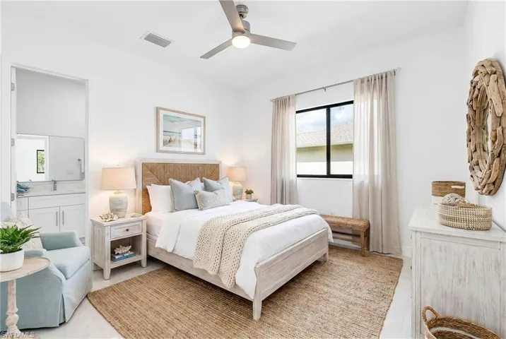 Bright bedroom featuring a ceiling fan, white walls, and a window with light-filtering drapes