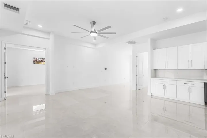 Open-concept living area featuring large format tile flooring and a contemporary ceiling fan