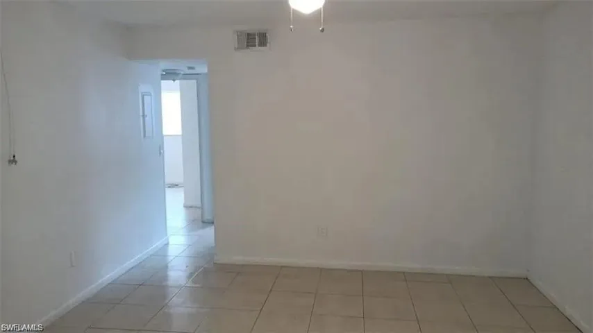 Empty room featuring light tile patterned flooring and baseboards