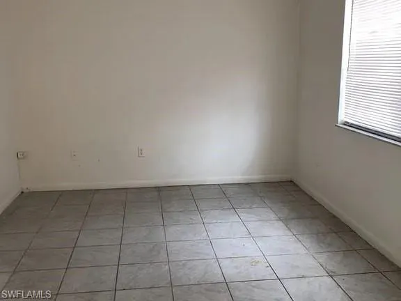 Spare room featuring light tile patterned floors and baseboards