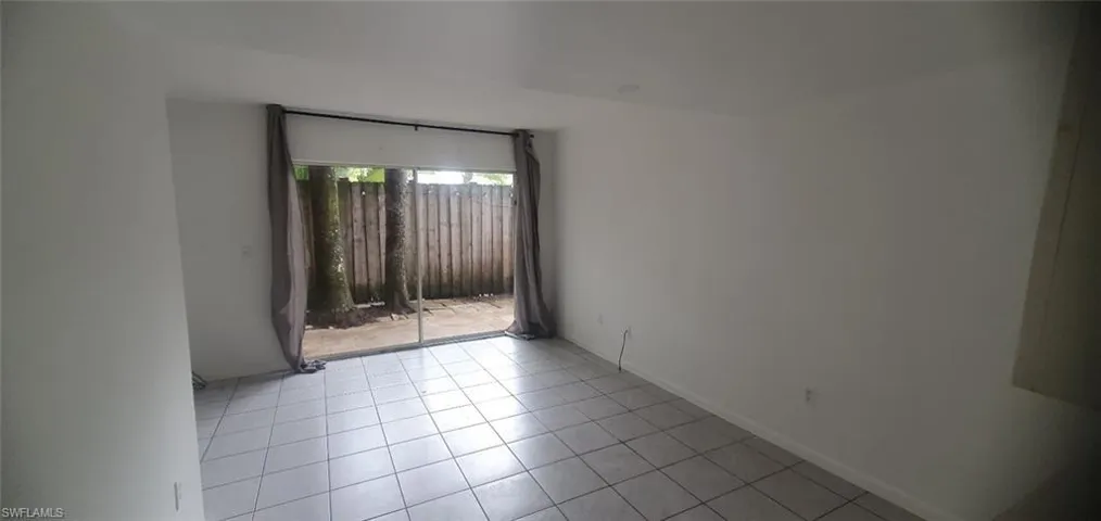 Tiled spare room featuring baseboards
