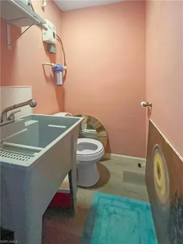 Half bath featuring toilet and baseboards