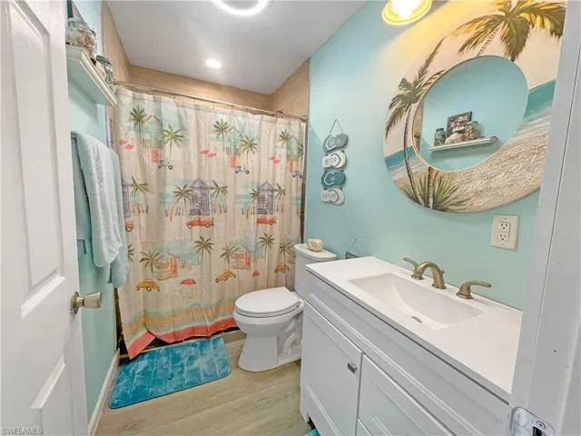 Full bath featuring vanity, a shower with shower curtain, and light wood finished floors