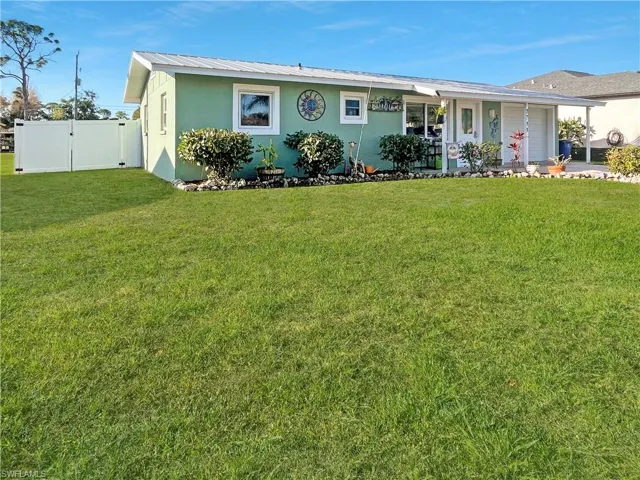 View of front of house featuring a gate, stucco siding, an attached garage, a porch, and a metal roof