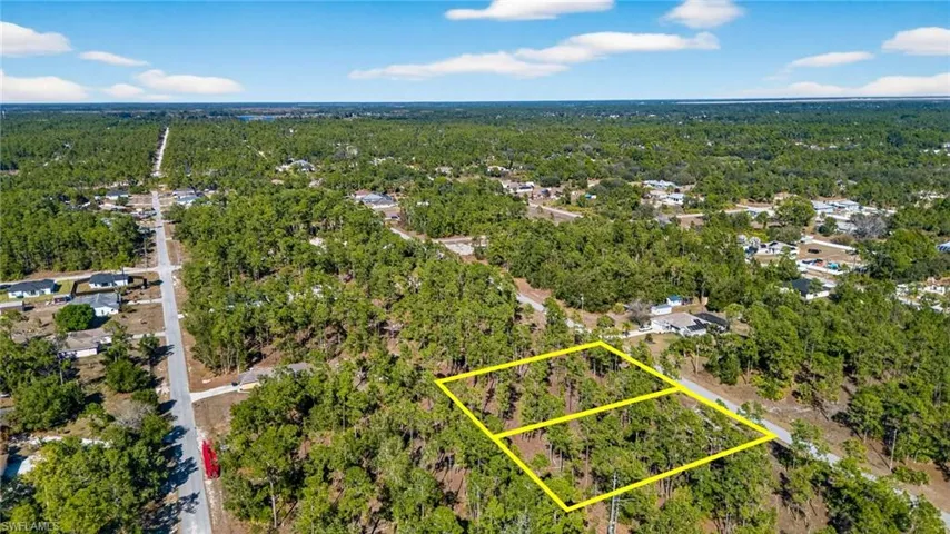 Aerial overview of property's location with a heavily wooded area and property parcel outlined