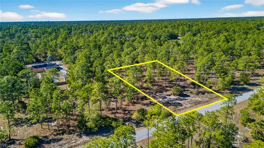 Aerial view of property's location featuring a heavily wooded area and property parcel outlined