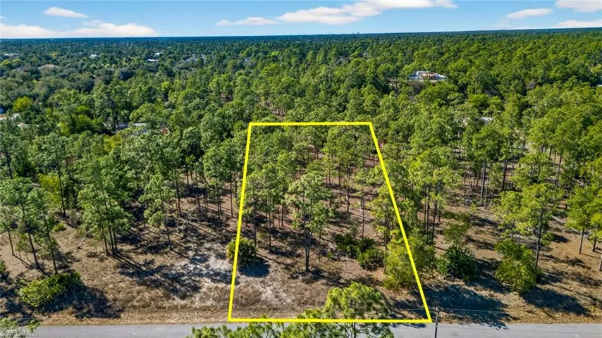 Aerial overview of property's location featuring property boundaries highlighted and a heavily wooded area