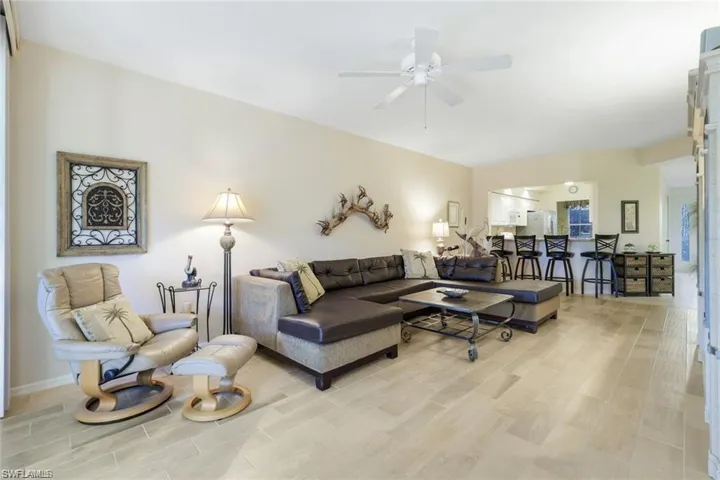 Living area featuring wood tiled floors and ceiling fan
