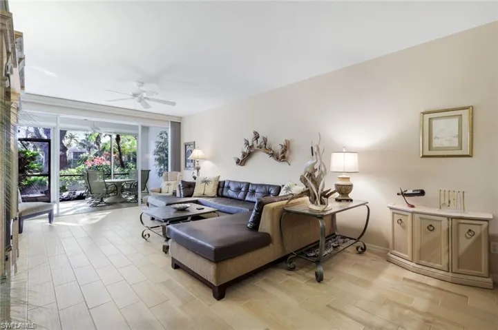 Living room featuring a ceiling fan, light wood-style flooring, and expansive windows
