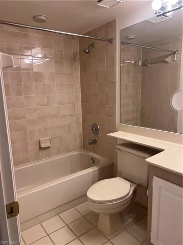 Full bathroom featuring vanity, toilet, tiled shower / bath combo, and tile patterned floors