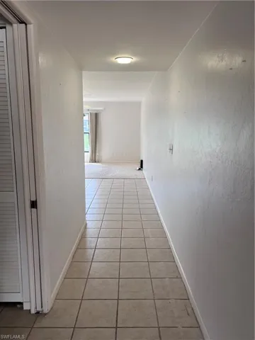 Corridor with light tile patterned flooring