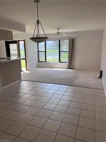 Carpeted empty room featuring ceiling fan