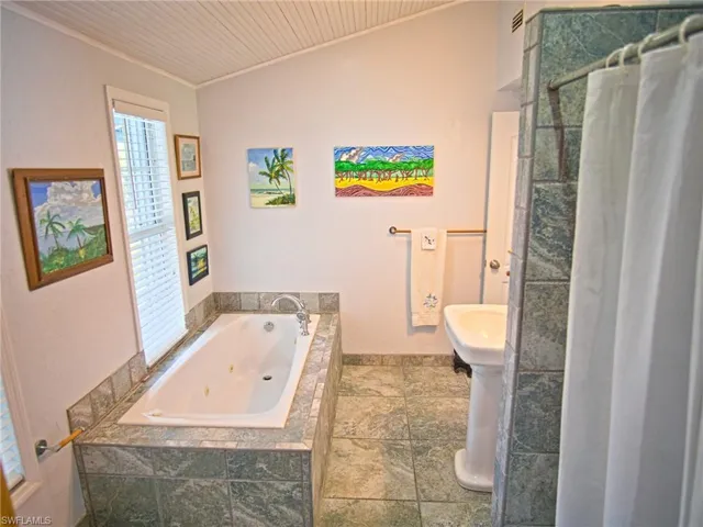 Upstairs, spa shower with modern wall sprayers and jetted tub