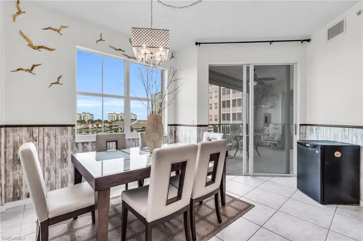 Dining space with light tile patterned floors and a chandelier