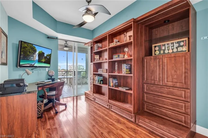 Office area with hardwood / wood-style flooring, ceiling fan, and floor to ceiling windows