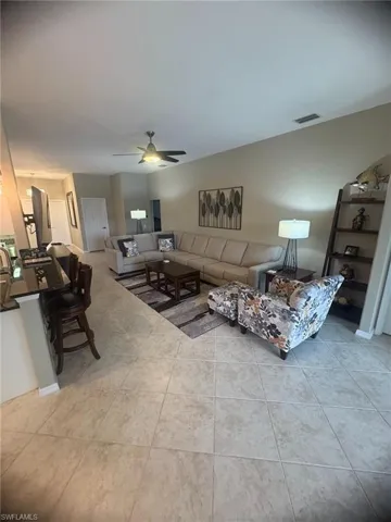 Living area featuring a ceiling fan and light tile patterned flooring