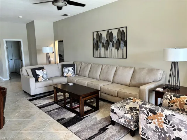 Living room with tile patterned flooring and ceiling fan