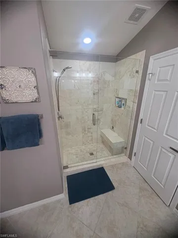 Bathroom with a stall shower and tile patterned flooring