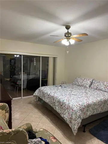Tiled bedroom featuring access to exterior and ceiling fan