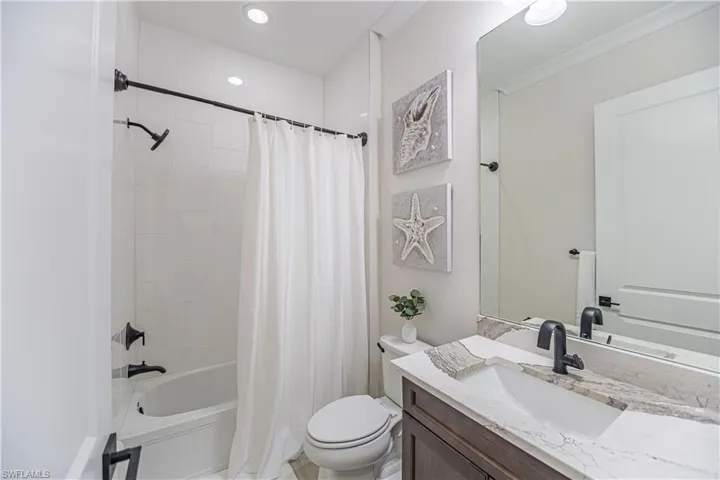 Full bathroom featuring vanity, ornamental molding, toilet, and shower / bath combo with shower curtain