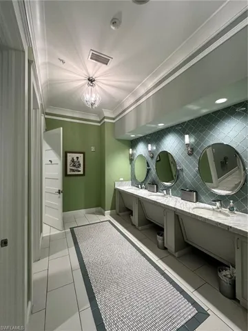 Clubhouse Bathroom featuring tile patterned flooring, crown molding, backsplash, and vanity