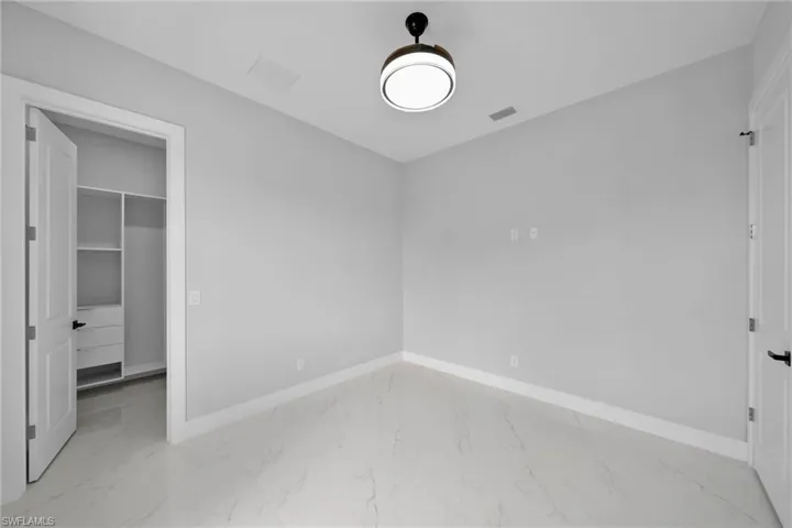 Unfurnished bedroom with a walk in closet and a closet