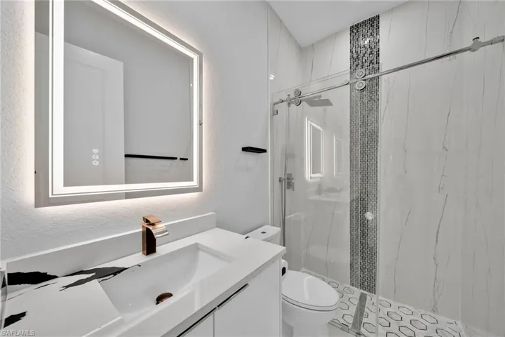 Bathroom with vanity, toilet, and a tile shower