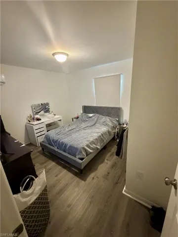 Room featuring wood-finish flooring, neutral wall tones, and a ceiling-mounted light fixture