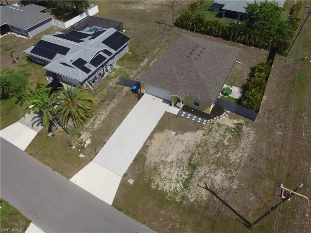 Single-story property with a light-colored exterior and a dark shingle roof