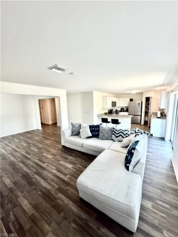 Expansive open-concept living space featuring wood-finish flooring, recessed lighting, and a neutral color palette