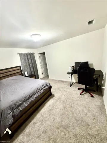 Spacious room featuring neutral carpeting and white wall finishes