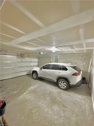 Interior garage space featuring concrete flooring, an overhead garage door, and block wall construction