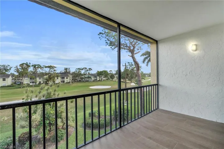 Balcony with a sunroom and view of golf course