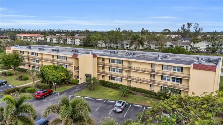View of apartment building / complex featuring uncovered parking