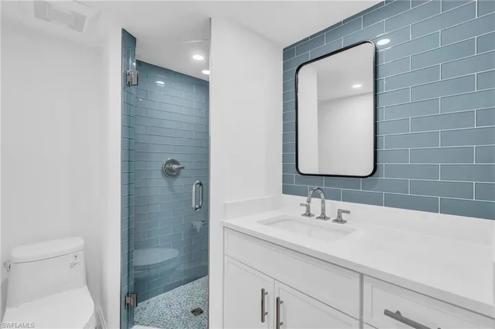 Full bath featuring a stall shower, vanity, and recessed lighting