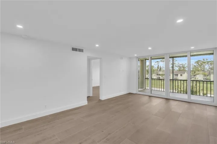 Spare room with recessed lighting, a residential view, light wood-style flooring, and a wall of windows