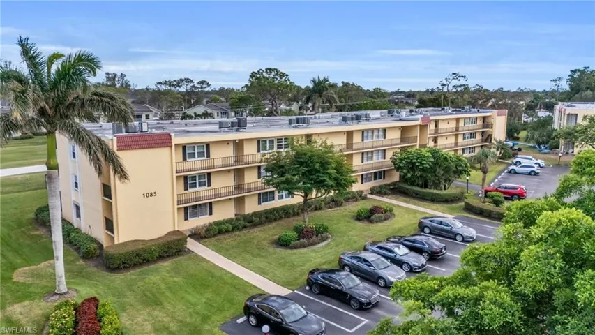 View of apartment building / complex with uncovered parking