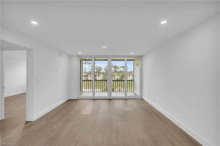 Unfurnished room with recessed lighting, floor to ceiling windows, and light wood-style flooring