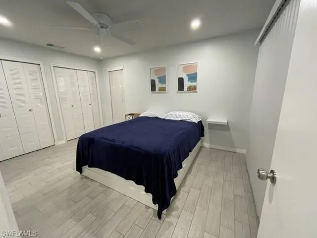 Bedroom with light wood finished floors, multiple closets, recessed lighting, baseboards, and a ceiling fan