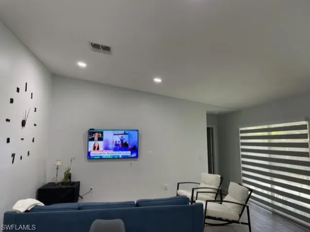 Living room with wood finished floors and recessed lighting